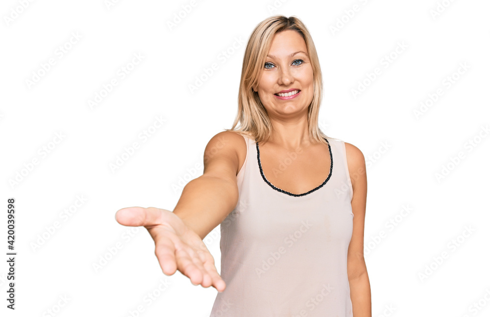 Middle age caucasian woman wearing casual clothes smiling friendly offering handshake as greeting and welcoming. successful business. Middle age caucasian woman wearing casual clothes smiling friendly offering handshake as greeting and welcoming. successful business.