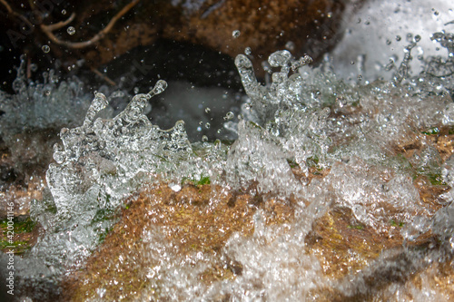 Splashes of water close-up. Different colors of water spray in the stream. The water droplets froze in the air