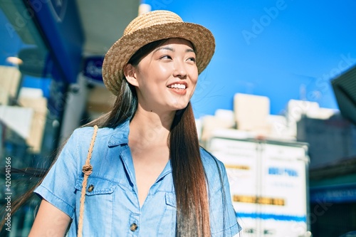 Young chinese tourist woman smiling happy walking at street of city. © Krakenimages.com