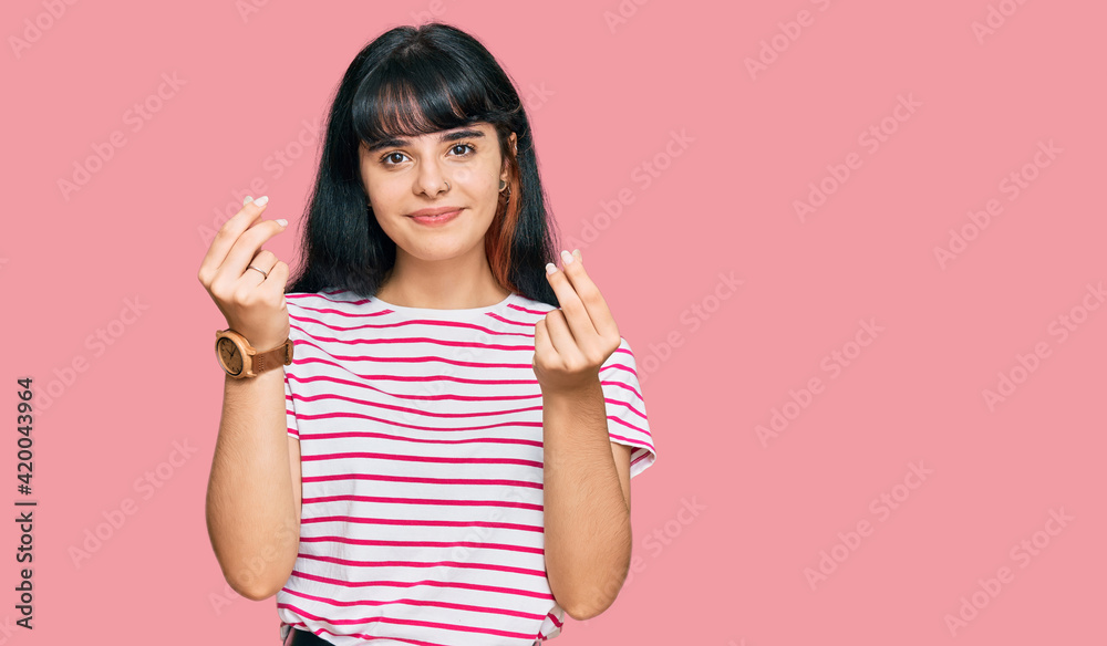 Young hispanic girl wearing casual clothes doing money gesture with hands, asking for salary payment, millionaire business Young hispanic girl wearing casual clothes doing money gesture with hands, asking for salary payment, millionaire business