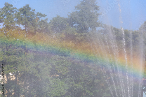 Splashes of water from fountain and reflection rainbow in sunlight close-up. Fog view  beautiful background  blur