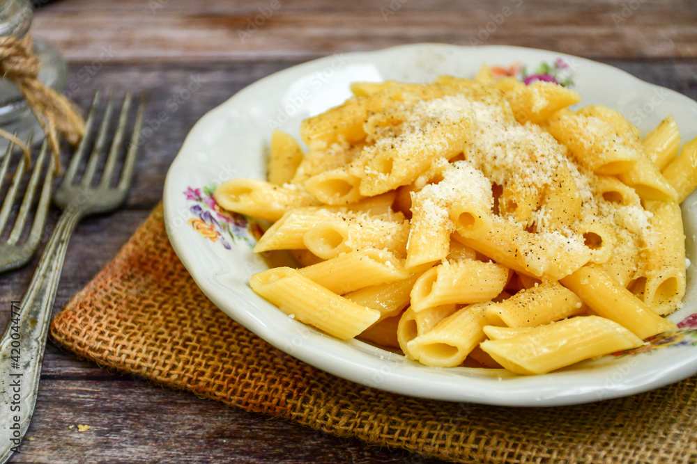 Home made italian penne rigate pasta with parmesan cheese,garlic and black pepper .Pasta cacio e pepe. Mediterranean food concept Home made italian penne rigate pasta with parmesan cheese,garlic and black pepper .Pasta cacio e pepe. Mediterranean food concept