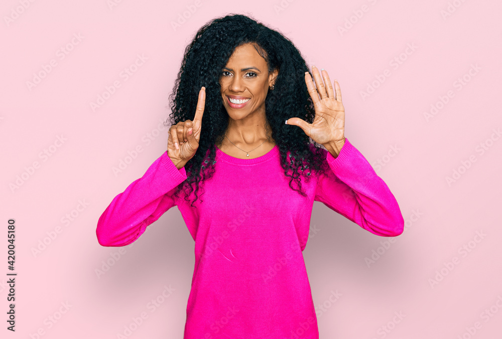 Middle age african american woman wearing casual clothes showing and pointing up with fingers number six while smiling confident and happy. Middle age african american woman wearing casual clothes showing and pointing up with fingers number six while smiling confident and happy.