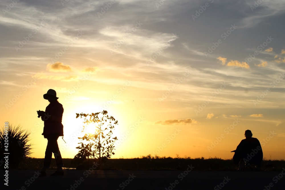 Silhouettes of people in the sunset swamp