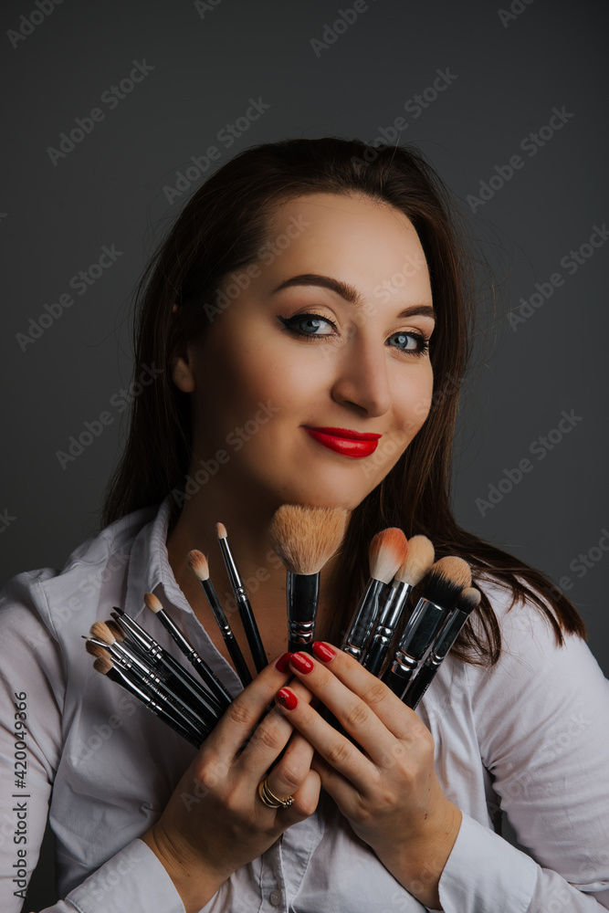 Woman holding a set of cosmetic brushes for make-up, Woman holding a set of cosmetic brushes for make-up,