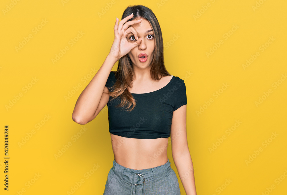 Young brunette woman wearing casual clothes doing ok gesture shocked with surprised face, eye looking through fingers. unbelieving expression. Young brunette woman wearing casual clothes doing ok gesture shocked with surprised face, eye looking through fingers. unbelieving expression.