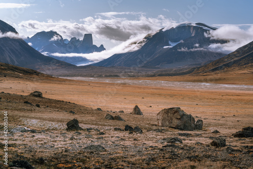 Owl River bed near Mt. Asgard, in arctic remote valley, Akshayuk Pass, Nunavut. Beautiful arctic landscape in the late, sunny afternoon. Iconic mountains on distant horizon. Autumn colors.