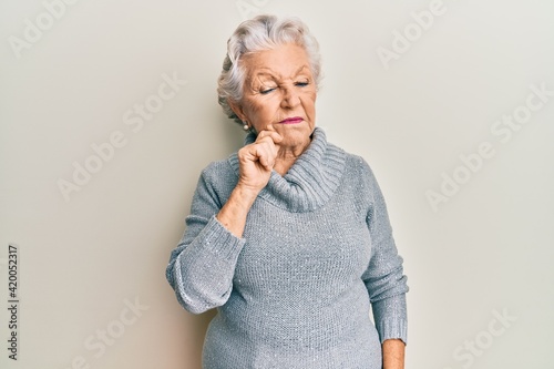 Senior grey-haired woman wearing casual clothes thinking concentrated about doubt with finger on chin and looking up wondering