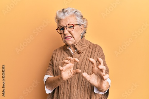 Konstfotografi Senior grey-haired woman wearing casual clothes and glasses disgusted expression, displeased and fearful doing disgust face because aversion reaction