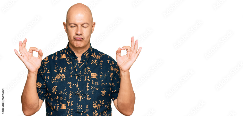Naklejka premium Middle age bald man wearing casual clothes relax and smiling with eyes closed doing meditation gesture with fingers. yoga concept.