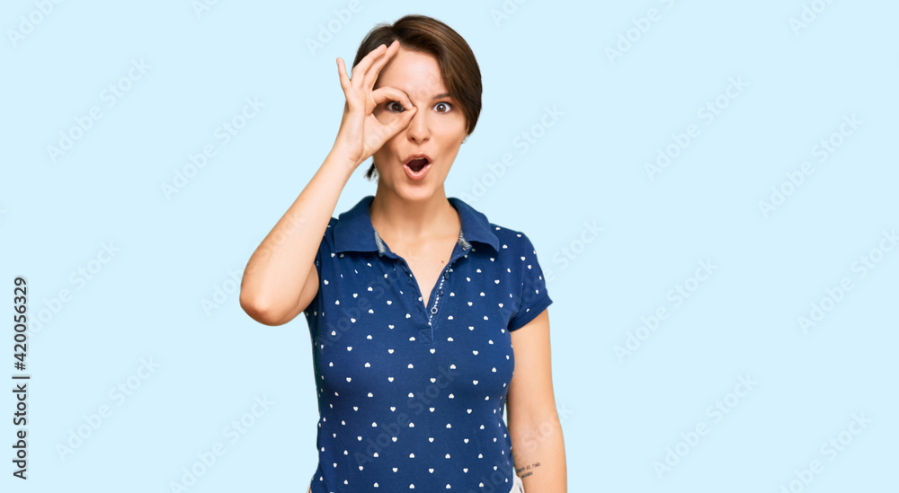 Young brunette woman with short hair wearing casual clothes doing ok gesture shocked with surprised face, eye looking through fingers. unbelieving expression. Young brunette woman with short hair wearing casual clothes doing ok gesture shocked with surprised face, eye looking through fingers. unbelieving expression.