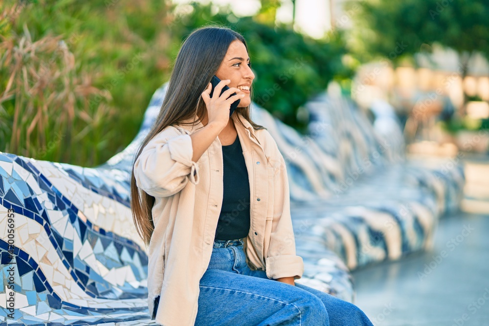 Young hispanic girl smiling happy talking on the smartphone at the park.