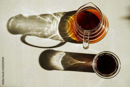 Third wave specialty coffee aesthetics. Freshly brewed black pour over coffee on sunlit white table.