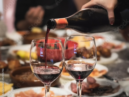 Sirviendo copas de vino en una mesa familiar con comida