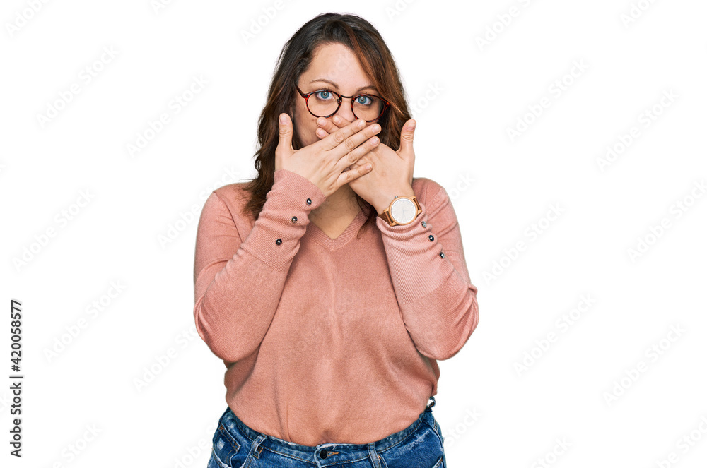 Young plus size woman wearing casual clothes and glasses shocked covering mouth with hands for mistake. secret concept. Young plus size woman wearing casual clothes and glasses shocked covering mouth with hands for mistake. secret concept.