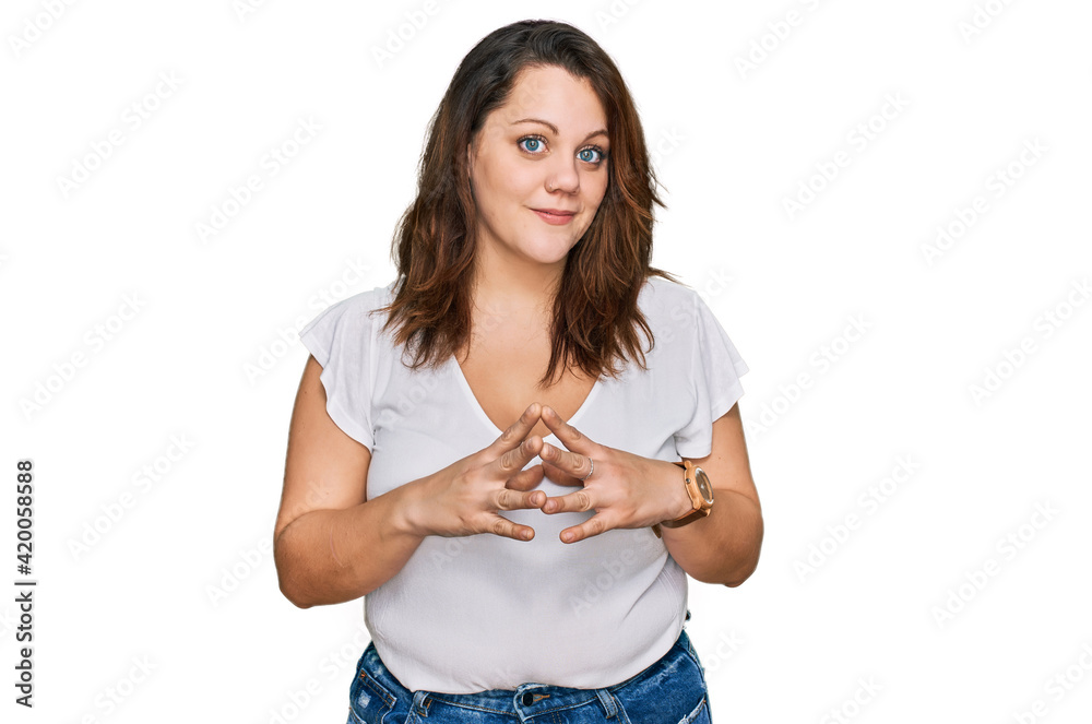 Young plus size woman wearing casual white t shirt hands together and fingers crossed smiling relaxed and cheerful. success and optimistic Young plus size woman wearing casual white t shirt hands together and fingers crossed smiling relaxed and cheerful. success and optimistic