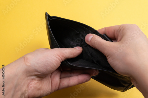 open an empty wallet at the end of the month. on a yellow background is the time to earn, selective focus