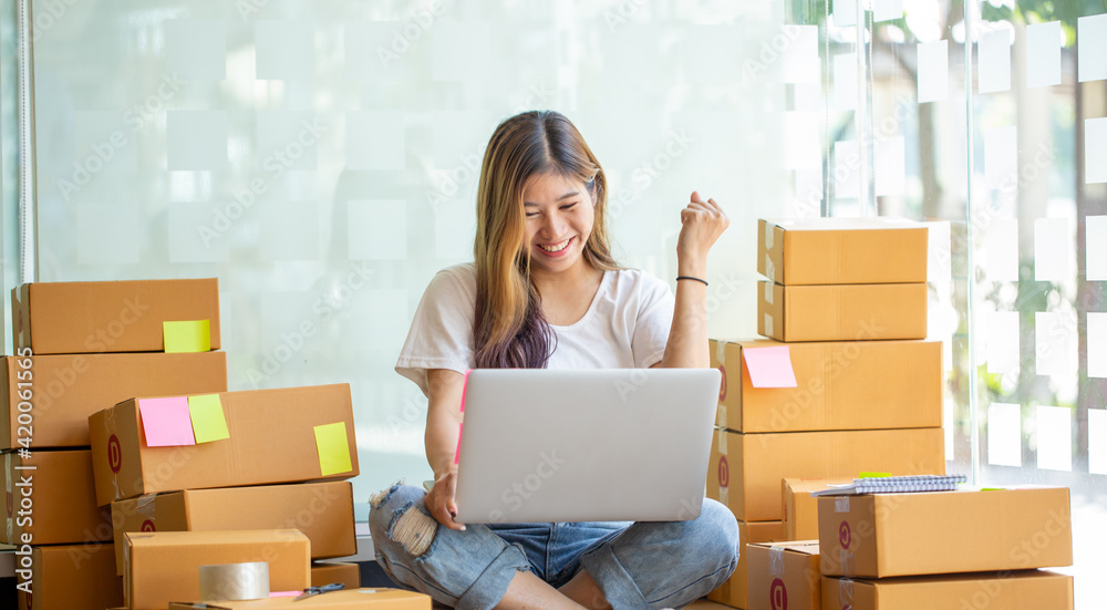 Starting Small business entrepreneur SME freelance,Portrait young woman working at home office, BOX,smartphone,laptop, online, marketing, packaging, delivery, SME, e-commerce concept Starting Small business entrepreneur SME freelance,Portrait young woman working at home office, BOX,smartphone,laptop, online, marketing, packaging, delivery, SME, e-commerce concept