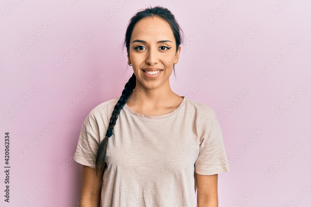 Fototapeta premium Young hispanic girl wearing casual white t shirt with a happy and cool smile on face. lucky person.