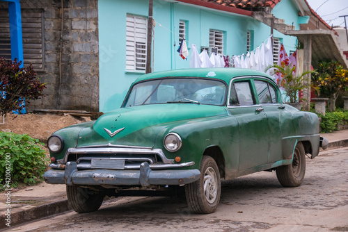 Un viejo coche americano aparcado frente a una casa en el pueblo de Viñales, Cuba