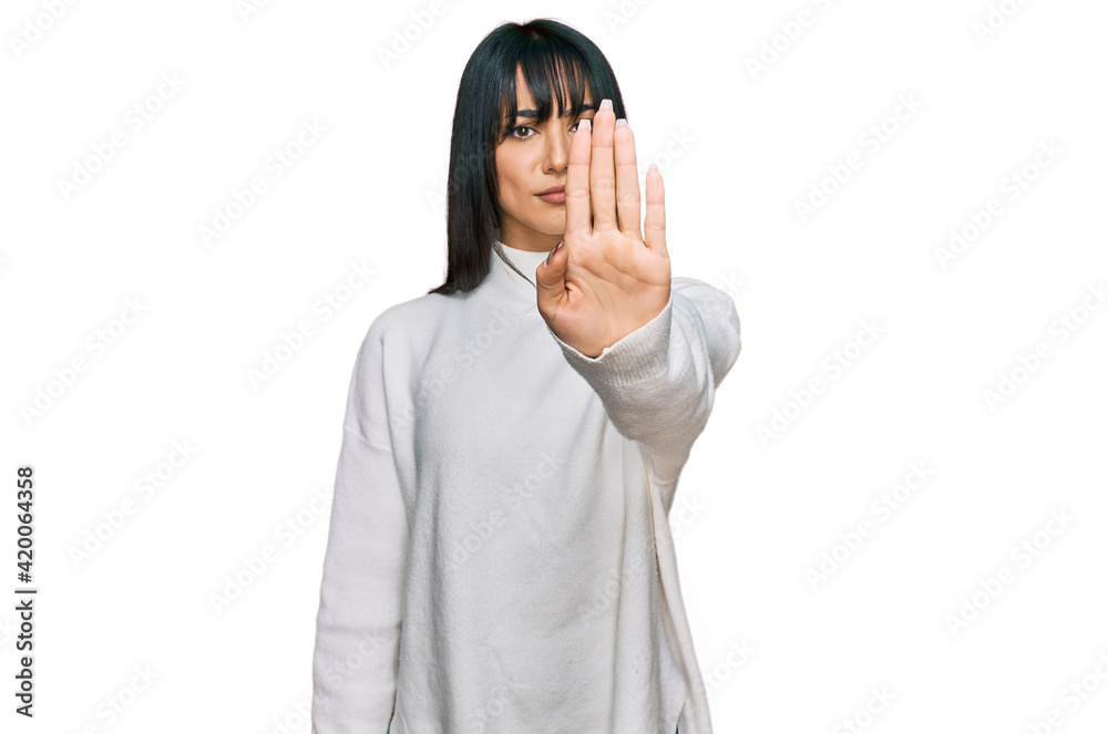 Young brunette woman with bangs wearing casual turtleneck sweater doing stop sing with palm of the hand. warning expression with negative and serious gesture on the face. Young brunette woman with bangs wearing casual turtleneck sweater doing stop sing with palm of the hand. warning expression with negative and serious gesture on the face.