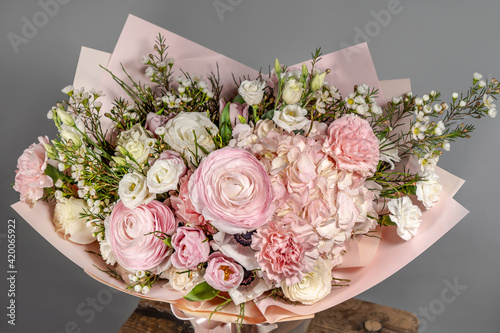 Rich bunch of pink and red flowers and lilac. Eustoma roses flowers, green leaf in glass vase. Fresh spring bouquet. Summer Background