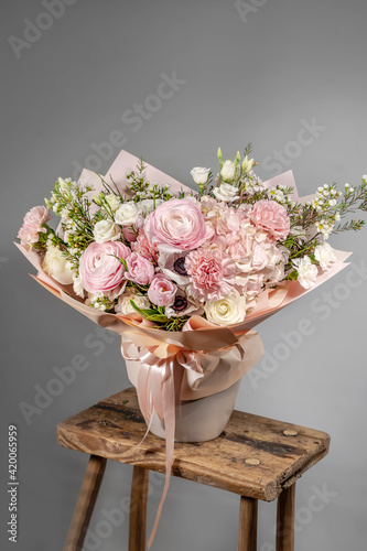 Rich bunch of pink and red flowers and lilac. Eustoma roses flowers, green leaf in glass vase. Fresh spring bouquet. Summer Background