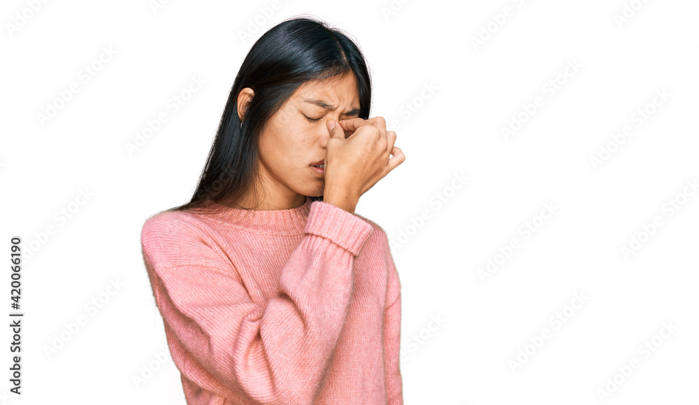 Beautiful young asian woman wearing casual winter sweater tired rubbing nose and eyes feeling fatigue and headache. stress and frustration concept. Beautiful young asian woman wearing casual winter sweater tired rubbing nose and eyes feeling fatigue and headache. stress and frustration concept.
