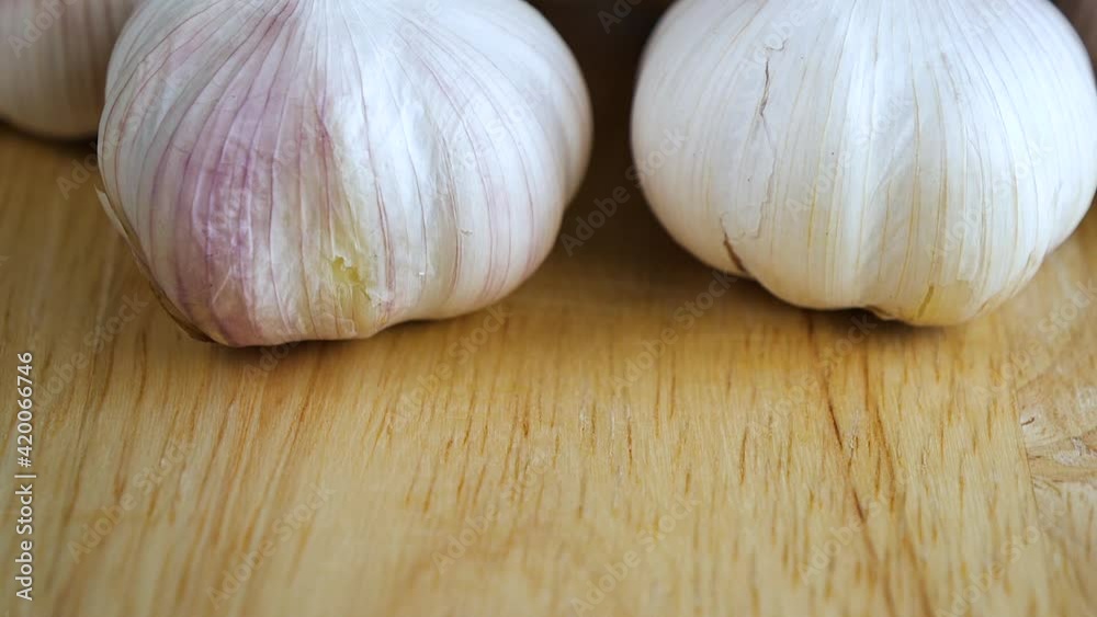 Top view slow motion of pouring garlic on wooden table Top view slow motion of pouring garlic on wooden table