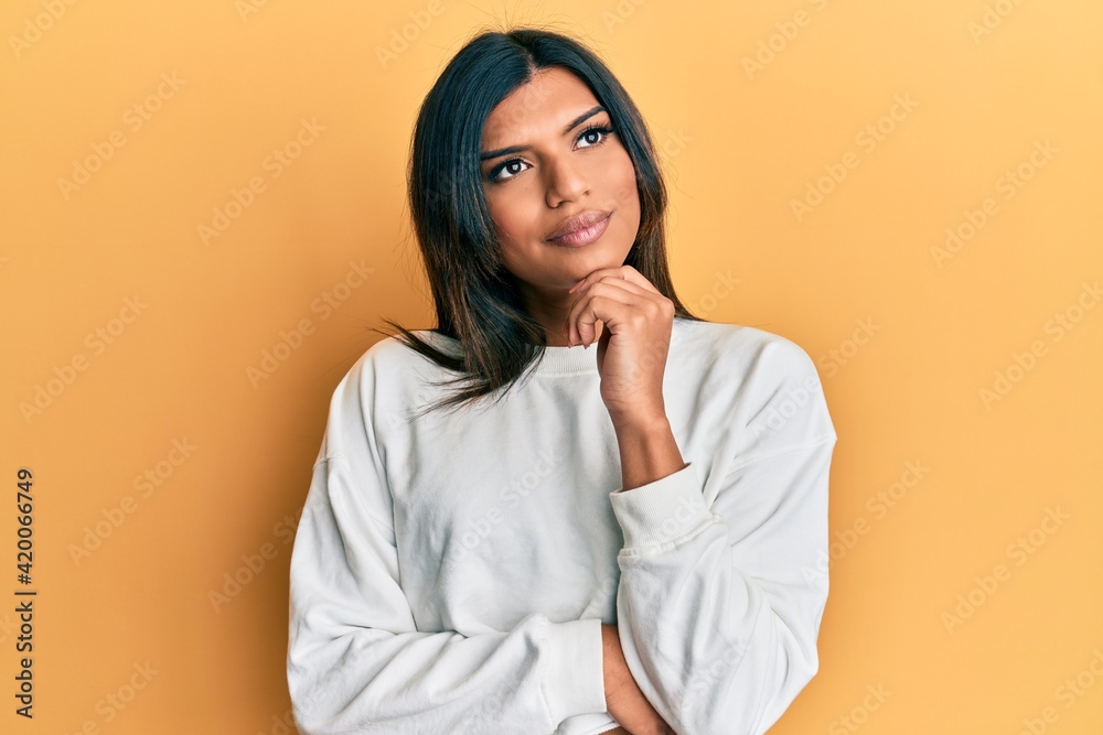 Young latin transsexual transgender woman wearing casual clothes thinking concentrated about doubt with finger on chin and looking up wondering Young latin transsexual transgender woman wearing casual clothes thinking concentrated about doubt with finger on chin and looking up wondering