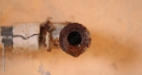 Water leaking from corroded pipe closeup footage
