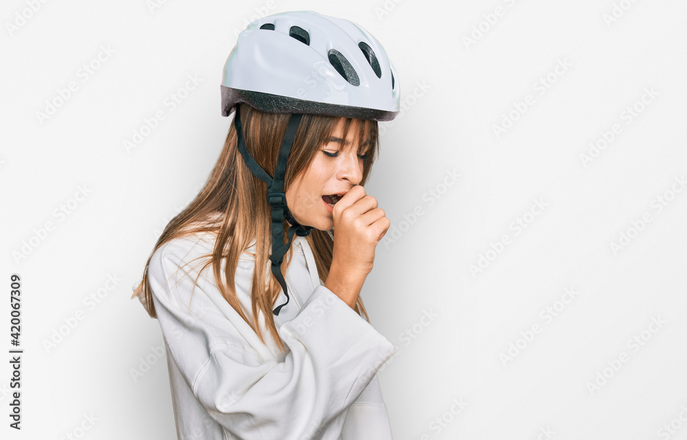 Teenager caucasian girl wearing bike helmet feeling unwell and coughing as symptom for cold or bronchitis. health care concept. Teenager caucasian girl wearing bike helmet feeling unwell and coughing as symptom for cold or bronchitis. health care concept.