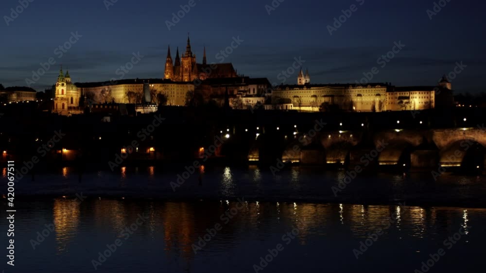 2view of the illuminated Prague Castle and St. Vitus Cathedral and Charles Bridge on the flowing Vltava River in the center of Prague after sunset 2view of the illuminated Prague Castle and St. Vitus Cathedral and Charles Bridge on the flowing Vltava River in the center of Prague after sunset