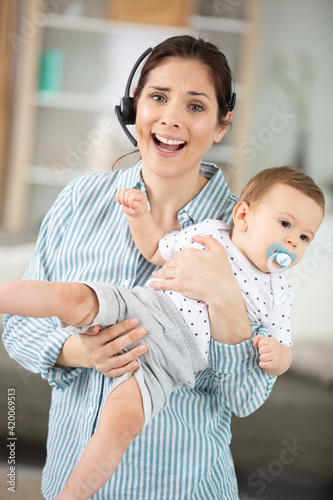 mother using telephone with baby in arms