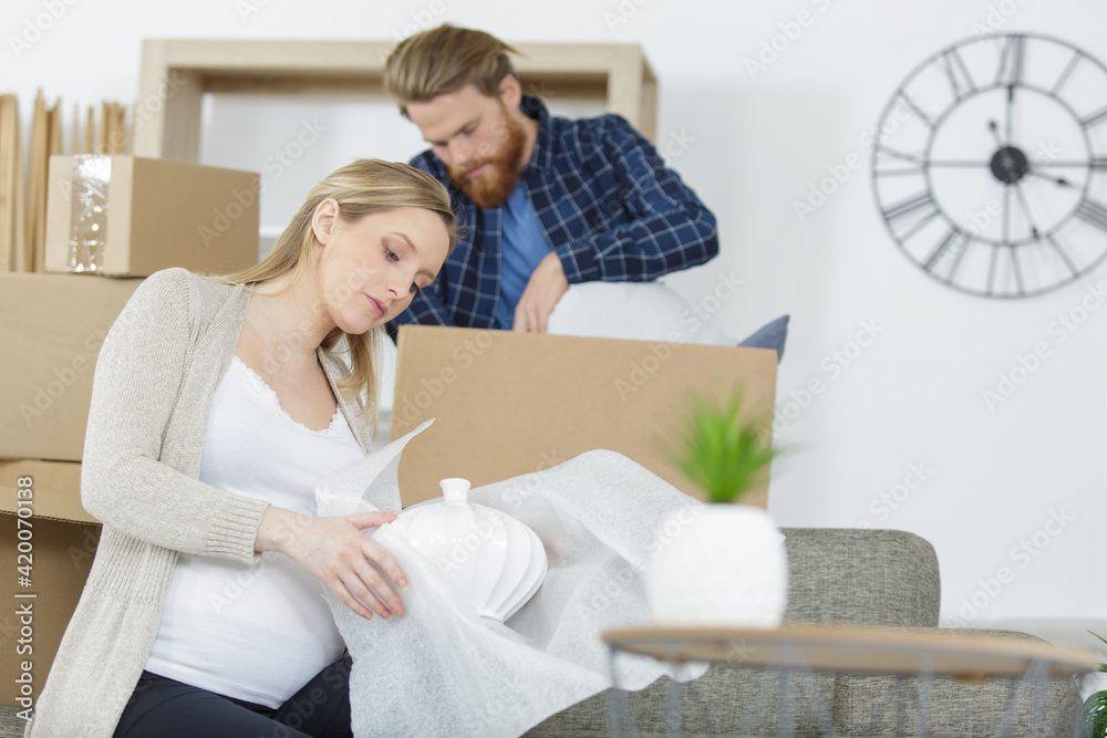 Obraz premium young couple moving to new flat with fragile possessions