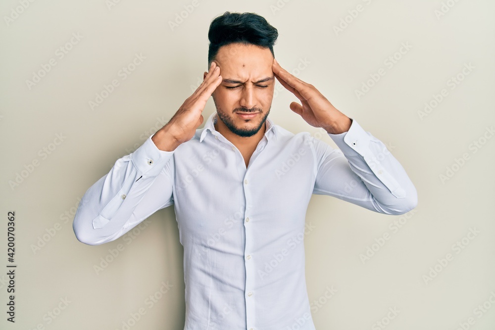 Young arab man wearing casual clothes with hand on head, headache because stress. suffering migraine. Young arab man wearing casual clothes with hand on head, headache because stress. suffering migraine.