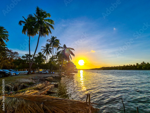 Pôr do sol na lagoa com nuvens no céu laranja