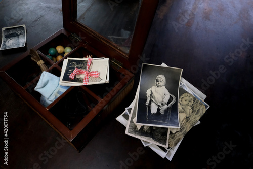 female hands are sorting dear to heart memorabilia in an old wooden box, stack of photos, vintage photographs of 1960, concept of family tree, genealogy, childhood memories, connection with ancestors