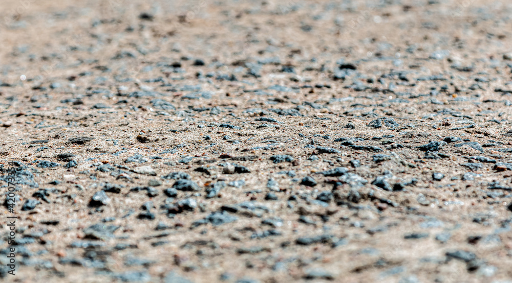black stone on grey sand, asphalt black stone on grey sand, asphalt