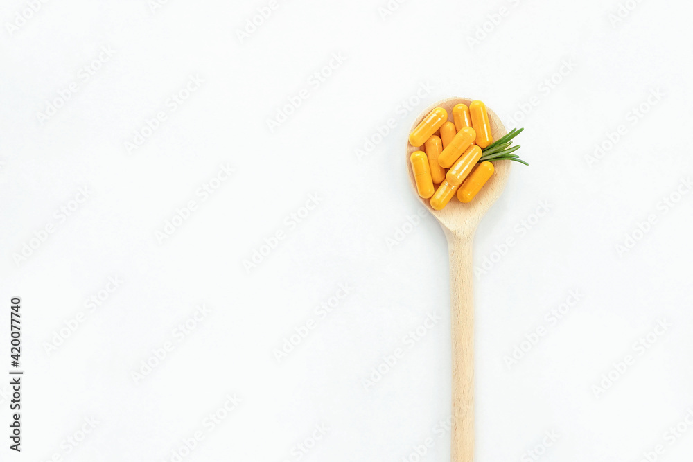 Wooden spoon with curcuma supplement on white background. Alternative medicine concept. Wooden spoon with curcuma supplement on white background. Alternative medicine concept.