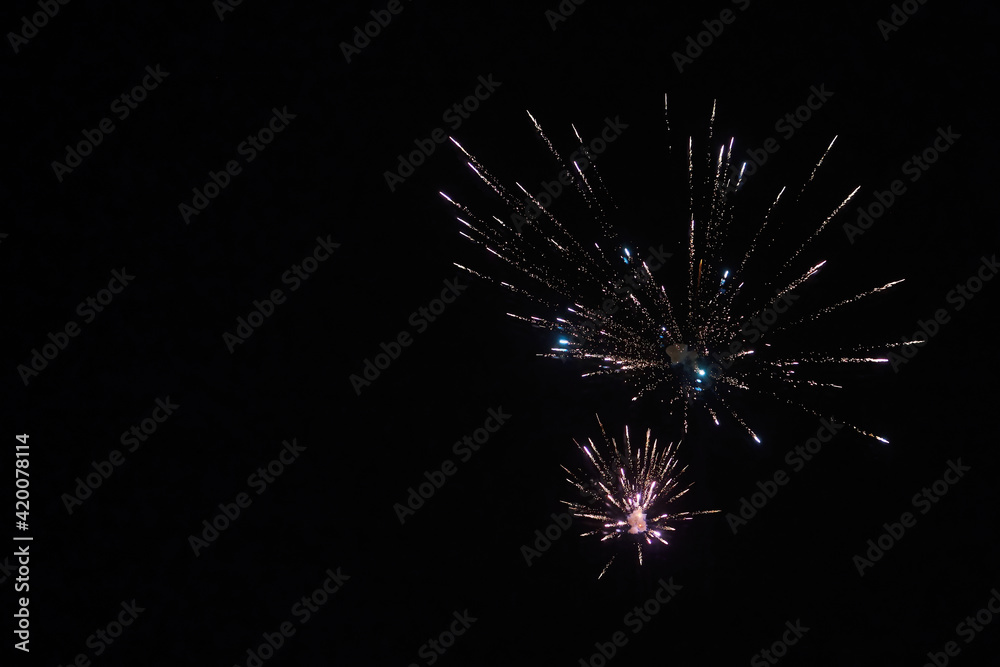 Light trace with bright burst and sparks from firework blowing up at dark night sky, long exposure