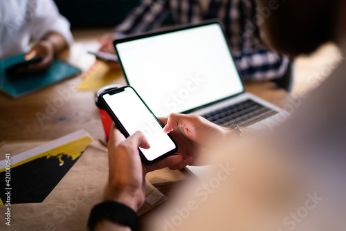 Cropped male connecting to 4g internet for browsing booking app on mockup mobile gadget with copy space area for web advertising, unrecognizable blogger networking and texting on blank cellphone