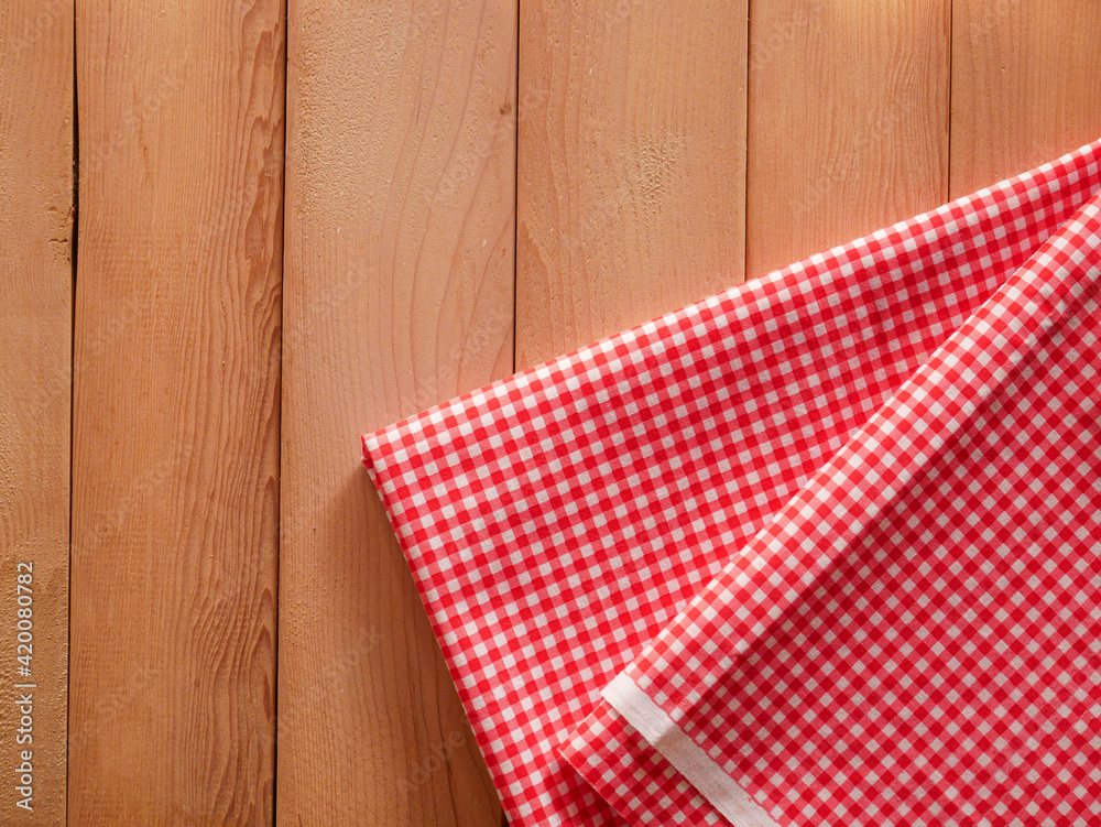 Fototapeta premium Classic pink plaid fabric or tablecloth on wood desk with copy space