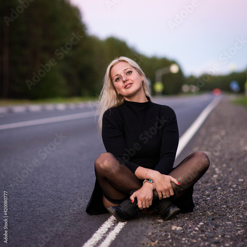 blonde girl in black dress on the road, selective focus