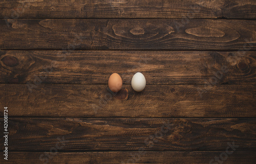 two different colored chicken eggs on wooden background