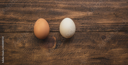 two different colored chicken eggs on wooden background