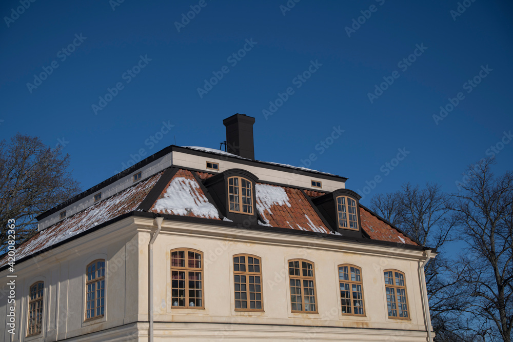 Snowy roof on a house from 1700s on the island Drottningholm in Stockholm