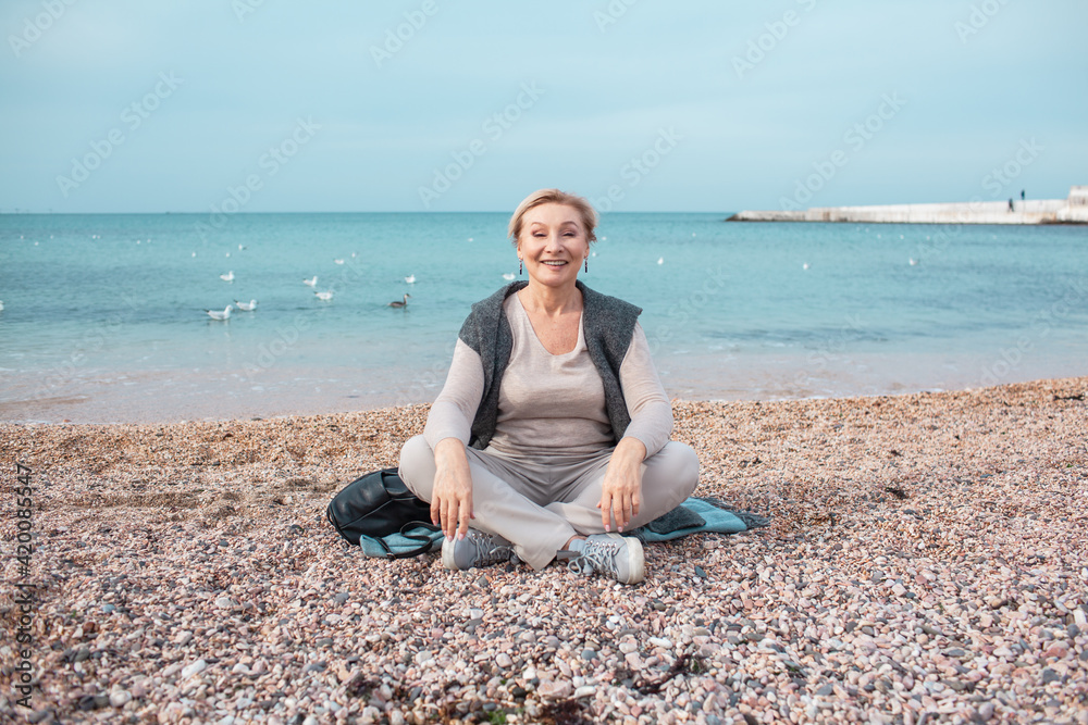 Beautiful middle-aged woman walking in the beach of the sea Beautiful middle-aged woman walking in the beach of the sea