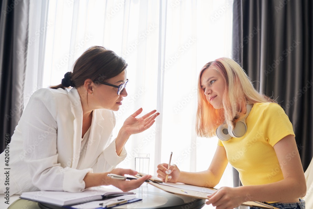 Woman social worker talking to teenage girl in office Woman social worker talking to teenage girl in office