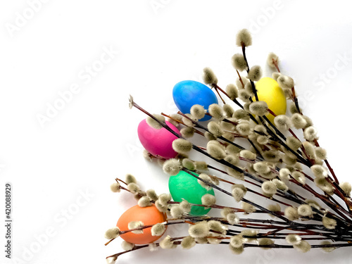 Easter.  Multicolored painted Easter eggs and pussy willow twigs isolated on a white background.  Minimal easter concept.  Happy Easter card with copy space for text.  Top view, flat lay